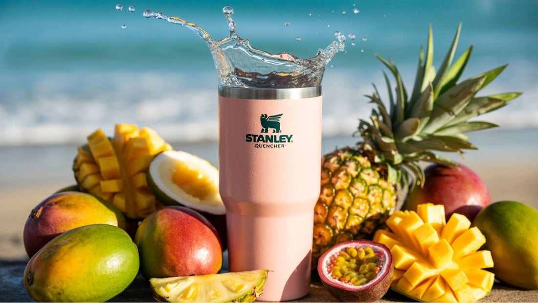 Stanley cup rose entourée de fruits sur la plage